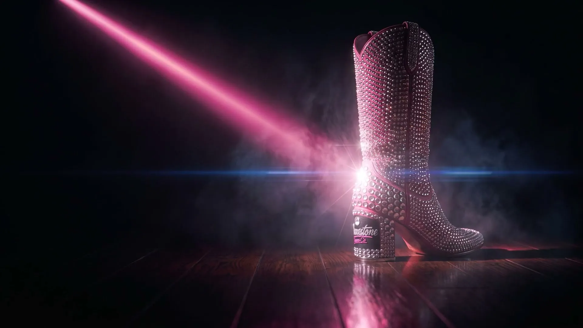 A crystal-covered cowboy boot lit by a single hot-pink laser beam in a dark haze.